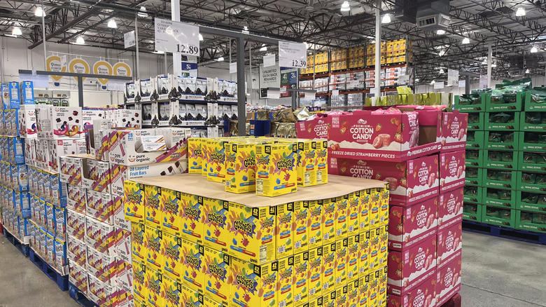 The crowded aisle of a Costco warehouse, stacked high with products