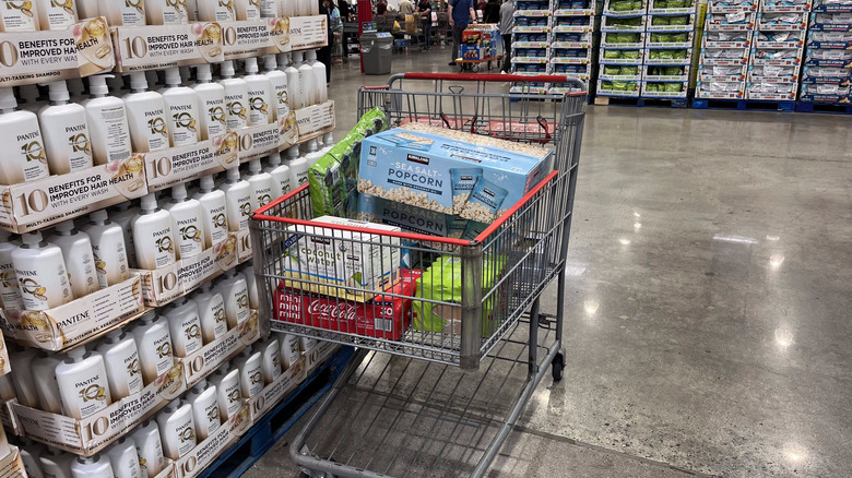 A Costco shopping cart full of groceries in the checkout line