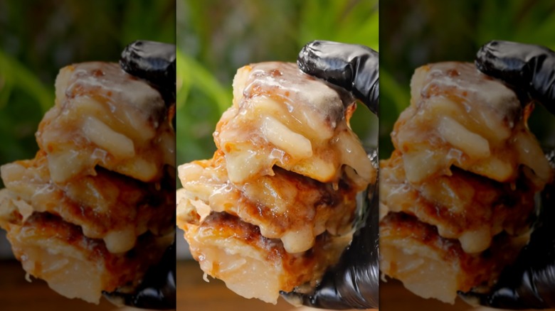 Apple pie Hawaiian rolls in gloved hand