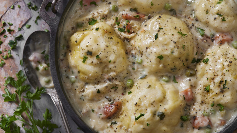 Chicken and dumplings in a pot with seasoning
