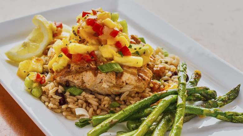 Plate with asparagus and a bed of rice topped with salmon and mango salsa