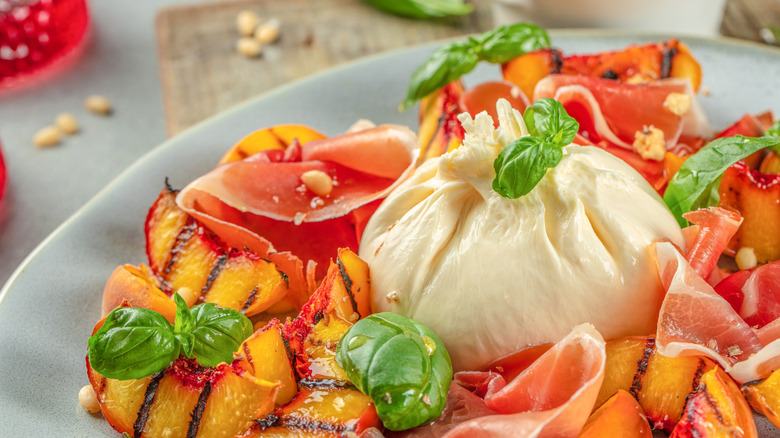 Burrata ball with peaches, basil, and meat