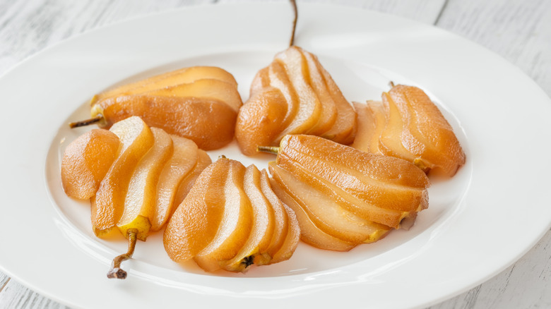 White wine poached pears on a white plate