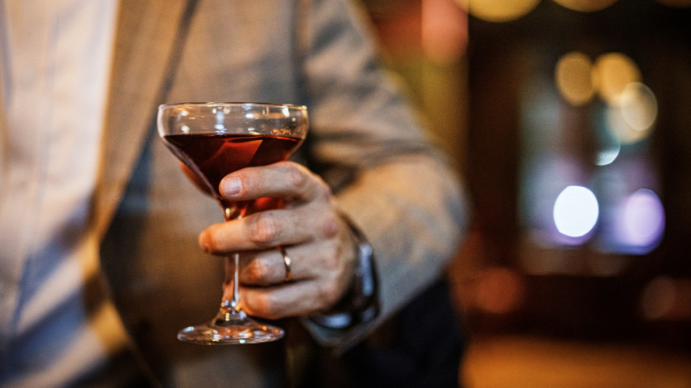Man holding Manhattan drink at cocktail lounge