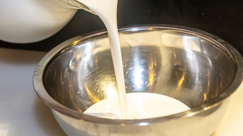 pouring cream in metal bowl