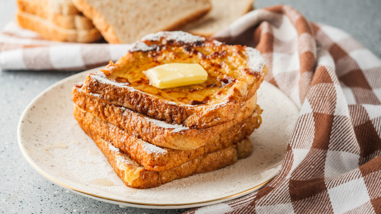 French toast on a plate with butter and syrup