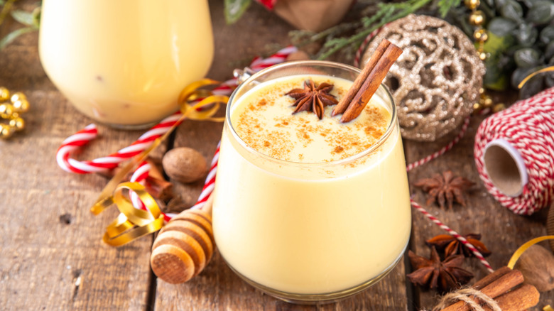 Glass of eggnog with candy canes and ornaments