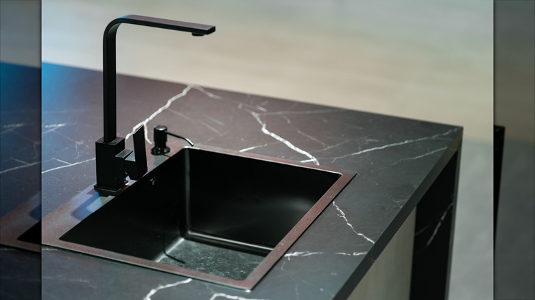 Kitchen sink with black marble countertop