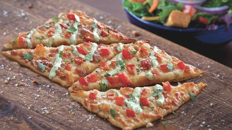 Fresh restaurant flatbread pizza on cutting board