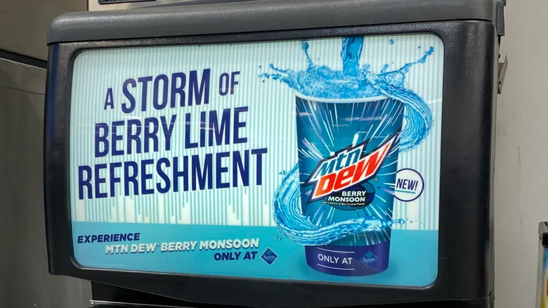 A promotional image of Mountain Dew Berry Monsoon flavor on the front of a self-serve soda fountain. The Ad reads "A Storm of Berry Lime Refreshment - Experience Mtn Dew Berry Monsoon only at Sams Club"