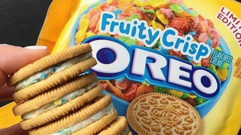 Someone holding a stack of Oreo Fruity Crisps in front of the packet