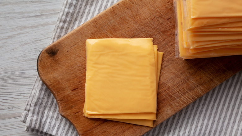 Slices of American cheese on a cutting board