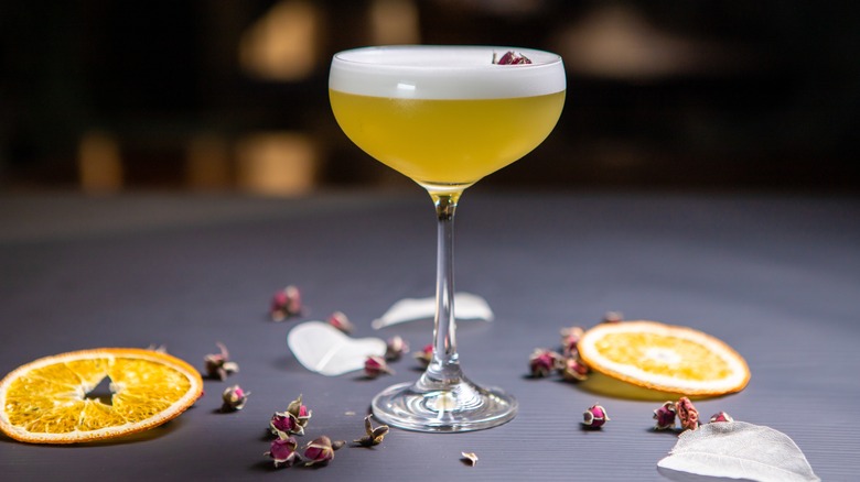 A Mezcal sour cocktail on a bar with orange slices