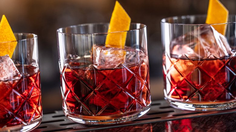 Three Smoky negroni cocktails garnished with orange slices