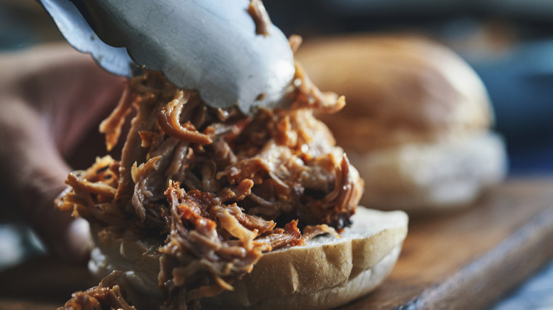 Sliders with pulled pork and tongs