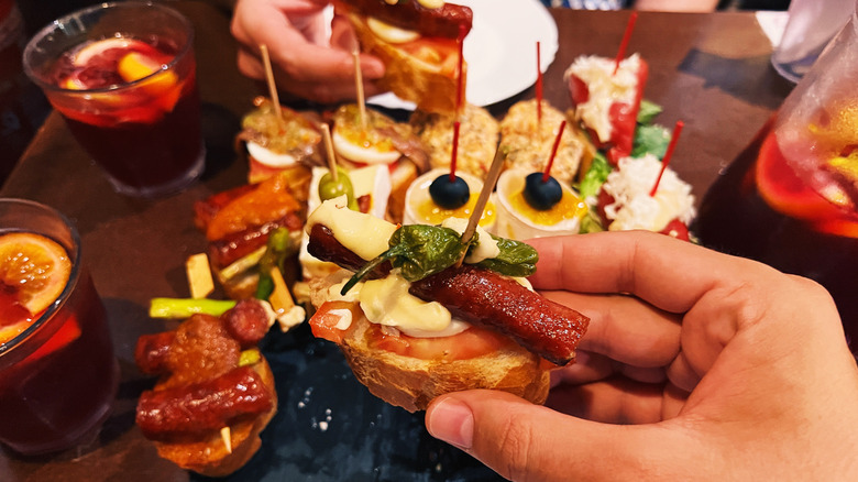 People holding small appetizers at a table
