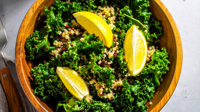 Kale salad in a bowl with lemons