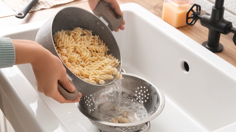 Pouring pasta into sink