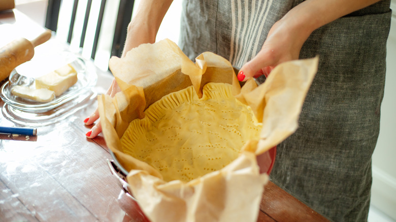 Person holding pie pan with pie crust