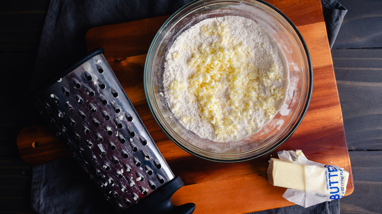 Grated frozen butter in a bowl with flour