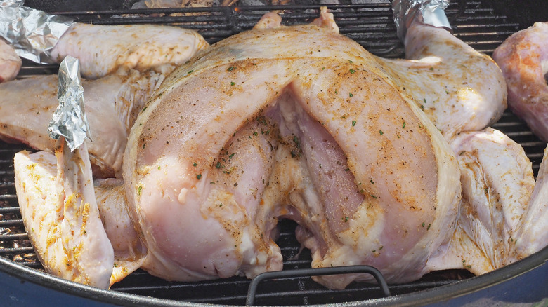 raw spatchcocked turkey on grill