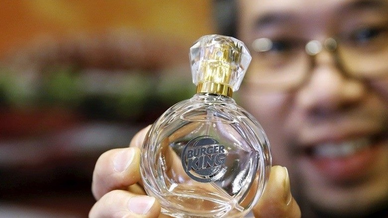 man holds Burger King perfume bottle