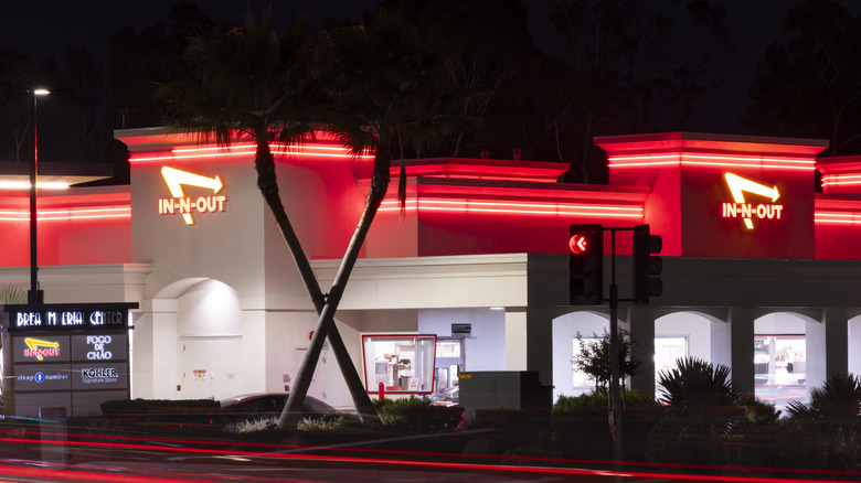 In-N-Out storefront at night with crossed palm trees