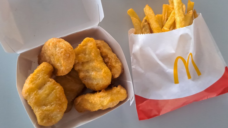 Six-Piece Chicken McNuggets sit on a table with fries.