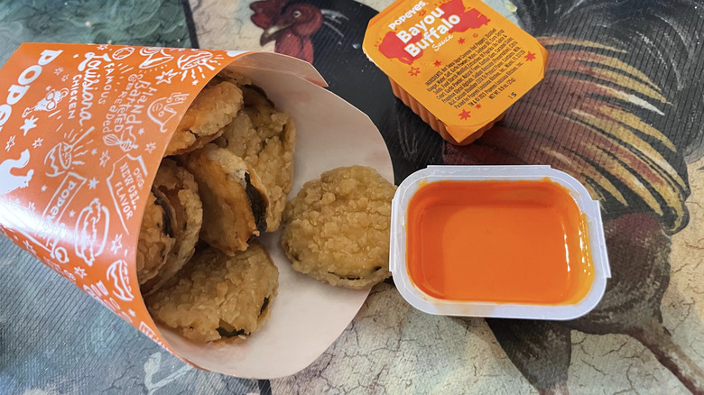 cup of Popeye's fried pickles with side of buffalo sauce