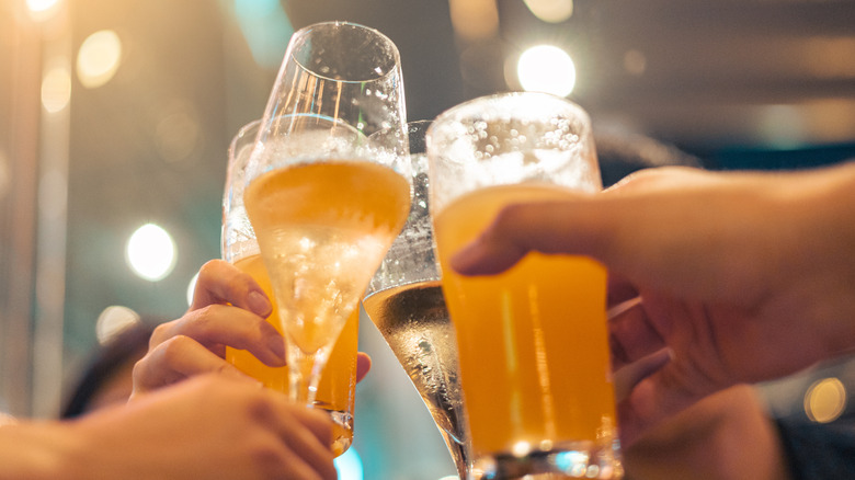 Hands toasting with beer and wine