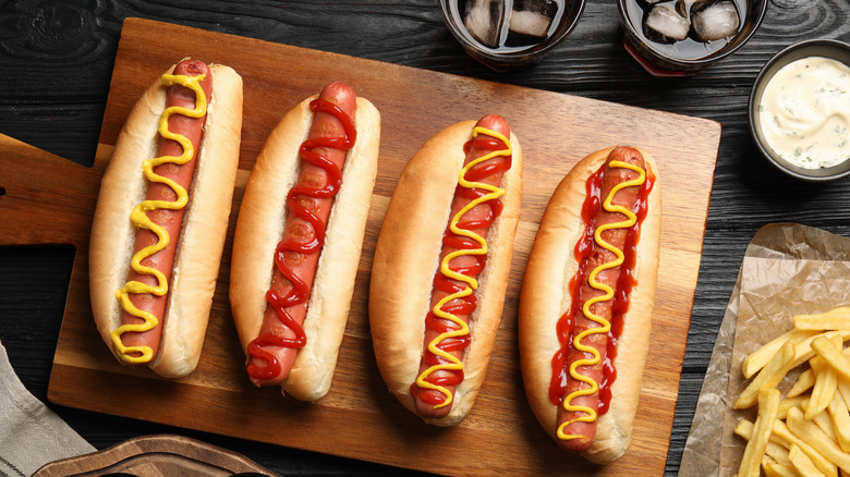 Four hot dogs with mustard and ketchup