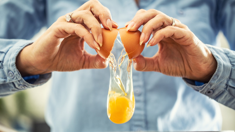 up-close of woman cracking a raw egg