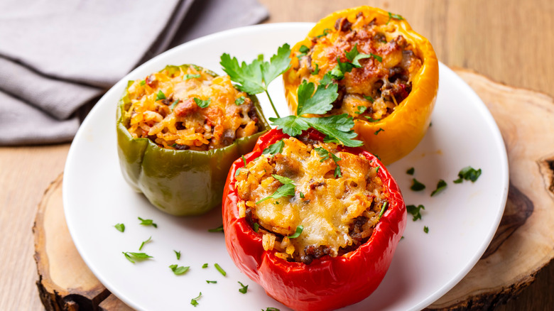 Stuffed peppers on a plate with cheese and herbs