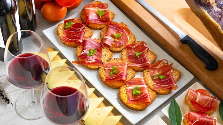 A plate of Spanish tapas with two glasses of wine