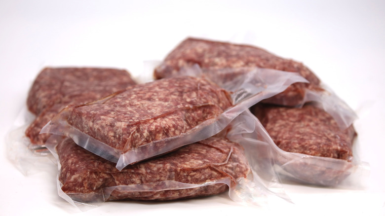 Frozen vaccuum-sealed meat on white background