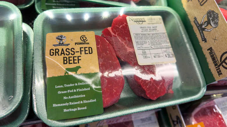 Grass-fed beef package sitting on a grocery store shelf with others