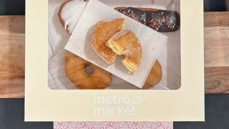 Metro Market sugar topped donut on wax paper on top of box of assorted donuts