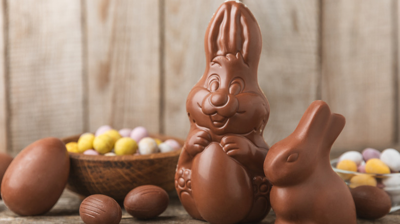 Two chocolate rabbits next to several chocolate Easter eggs