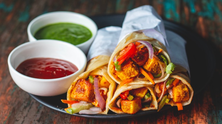 A plate fo kathi rolls with condiments