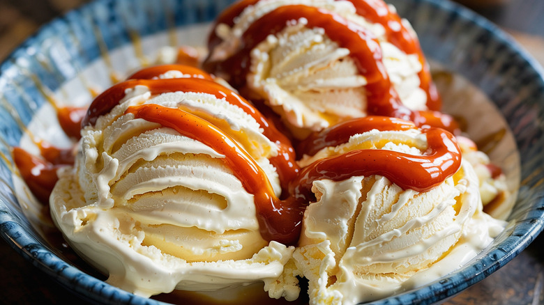 Three scoops of vanilla ice cream drizzled in hot sauce