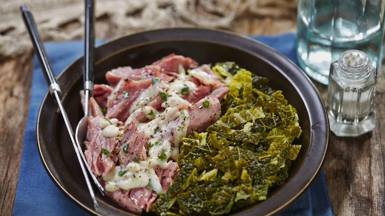 A plate of boiled cabbage and bacon on a table