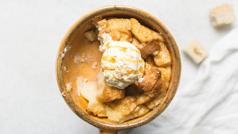 A bowl of bread and butter pudding with ice cream