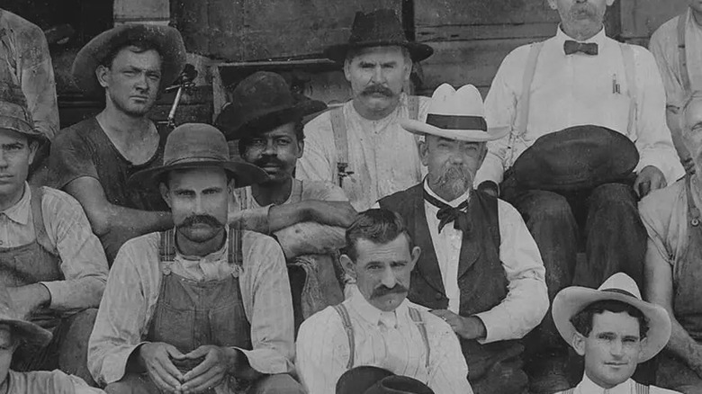 Black and white photo of Jack Daniels with distillery staff