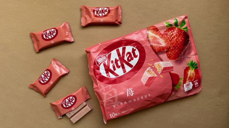 Opened bag of Strawberry Kit Kats surrounded by individually wrapped pieces