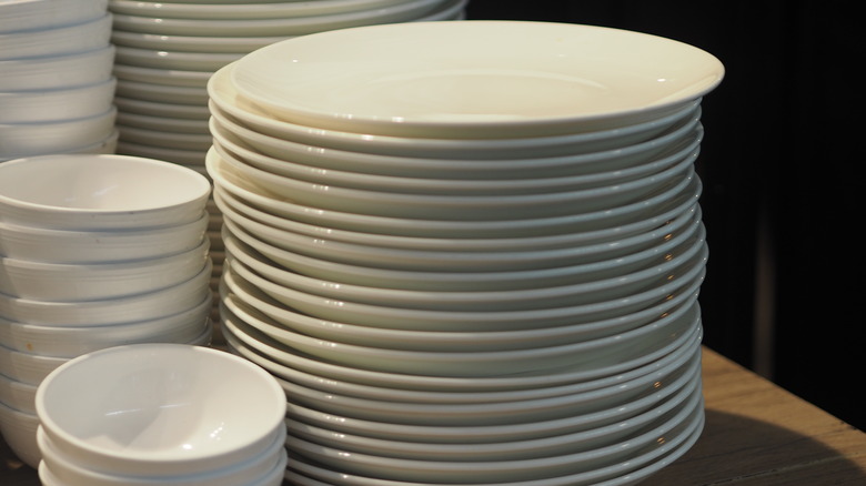 A stack of plain white plates and bowls