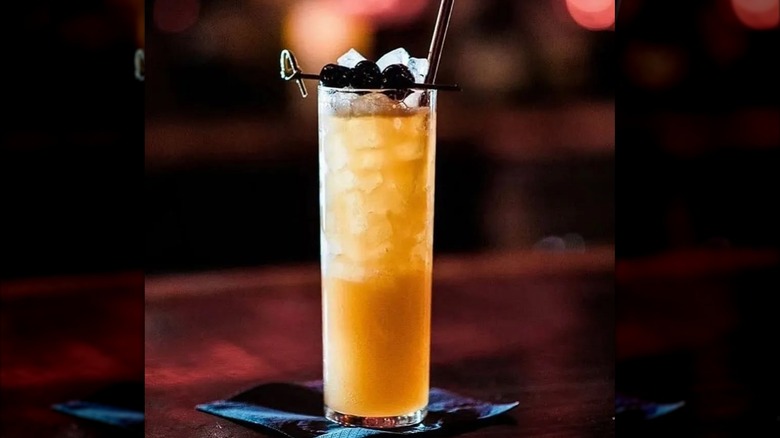 A Three Dots and a Dash cocktail garnished with cherries