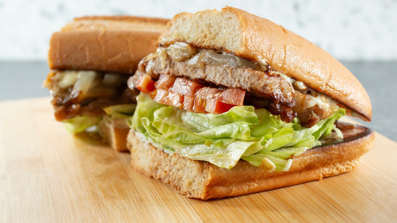 Ribeye steak sandwich on wooden cutting board
