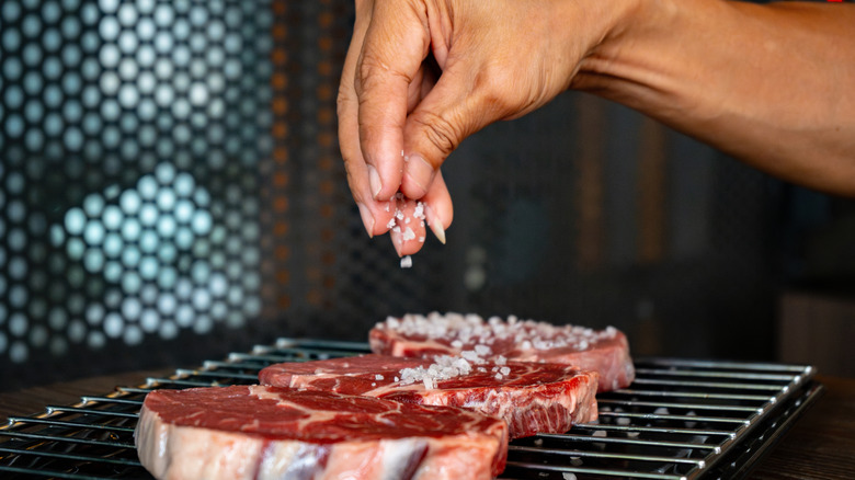 Person seasoning ribeye steak