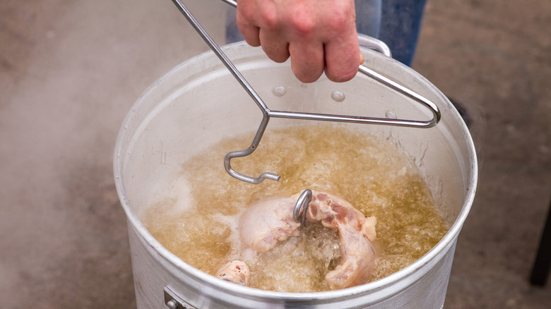 Person lowering bird into oil