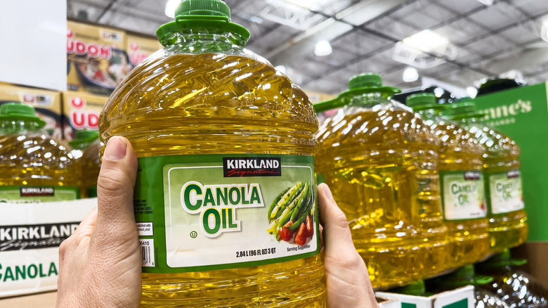 Person holding a container of canola oil